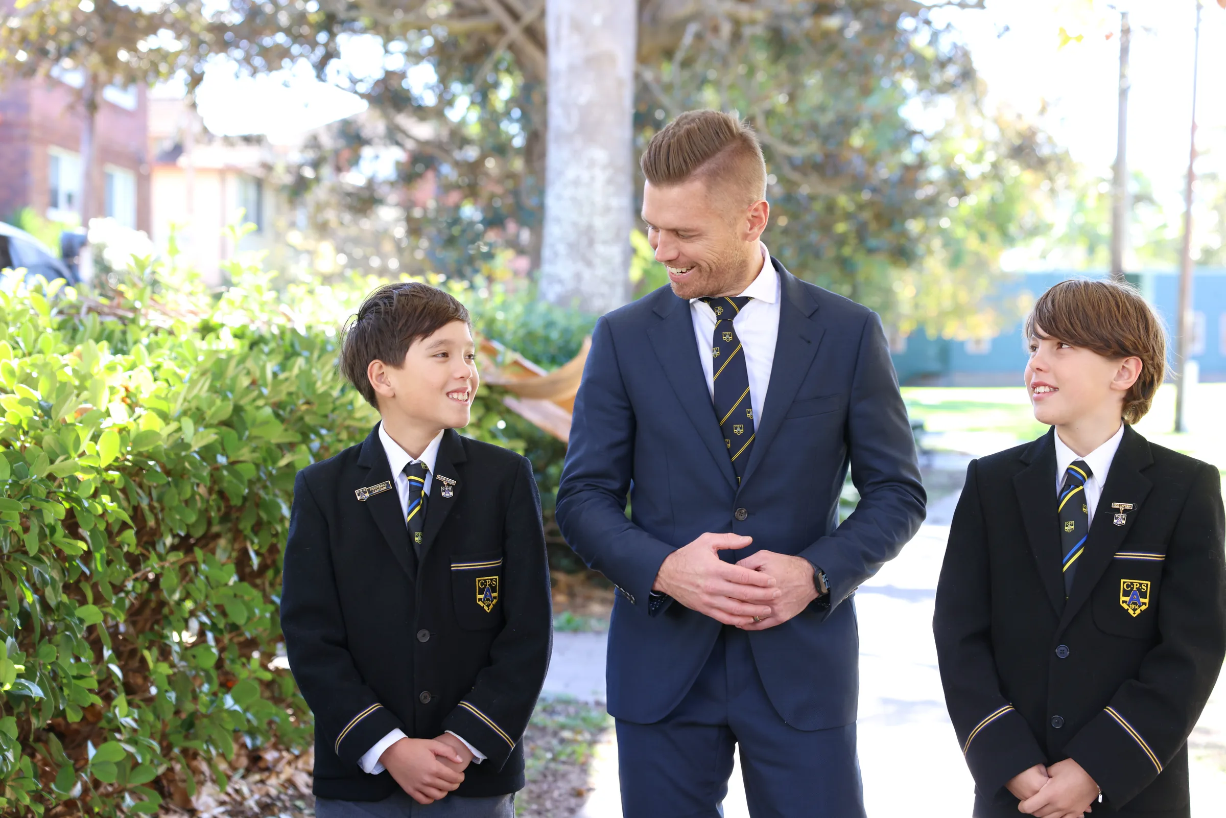 Jason Wren-Pattison outside the School with two Coogee Prep boys