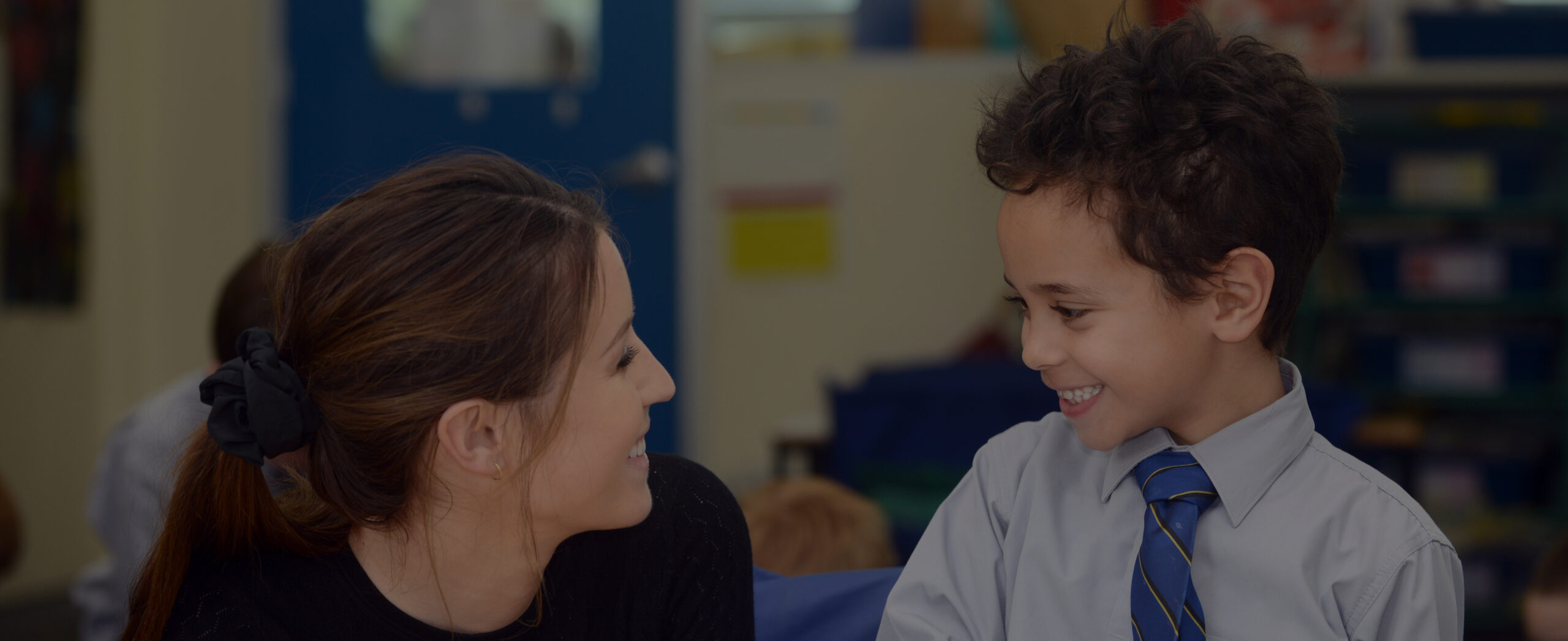 A Coogee Prep teacher listening to a boy in class