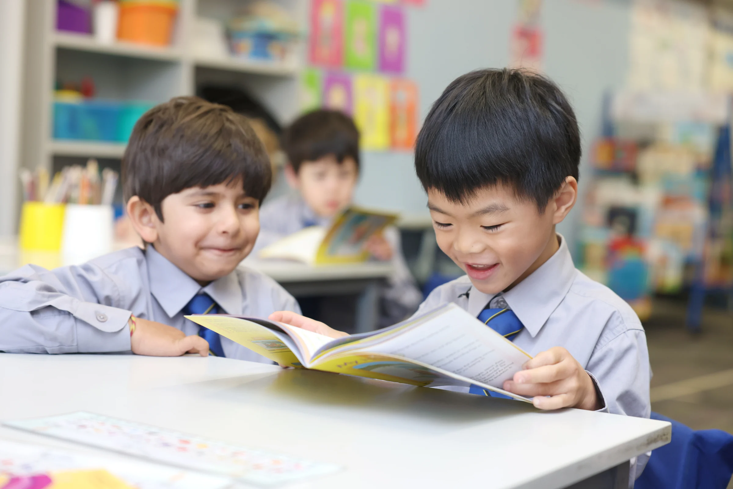 Two Coogee Prep boys reading a book together at a desk