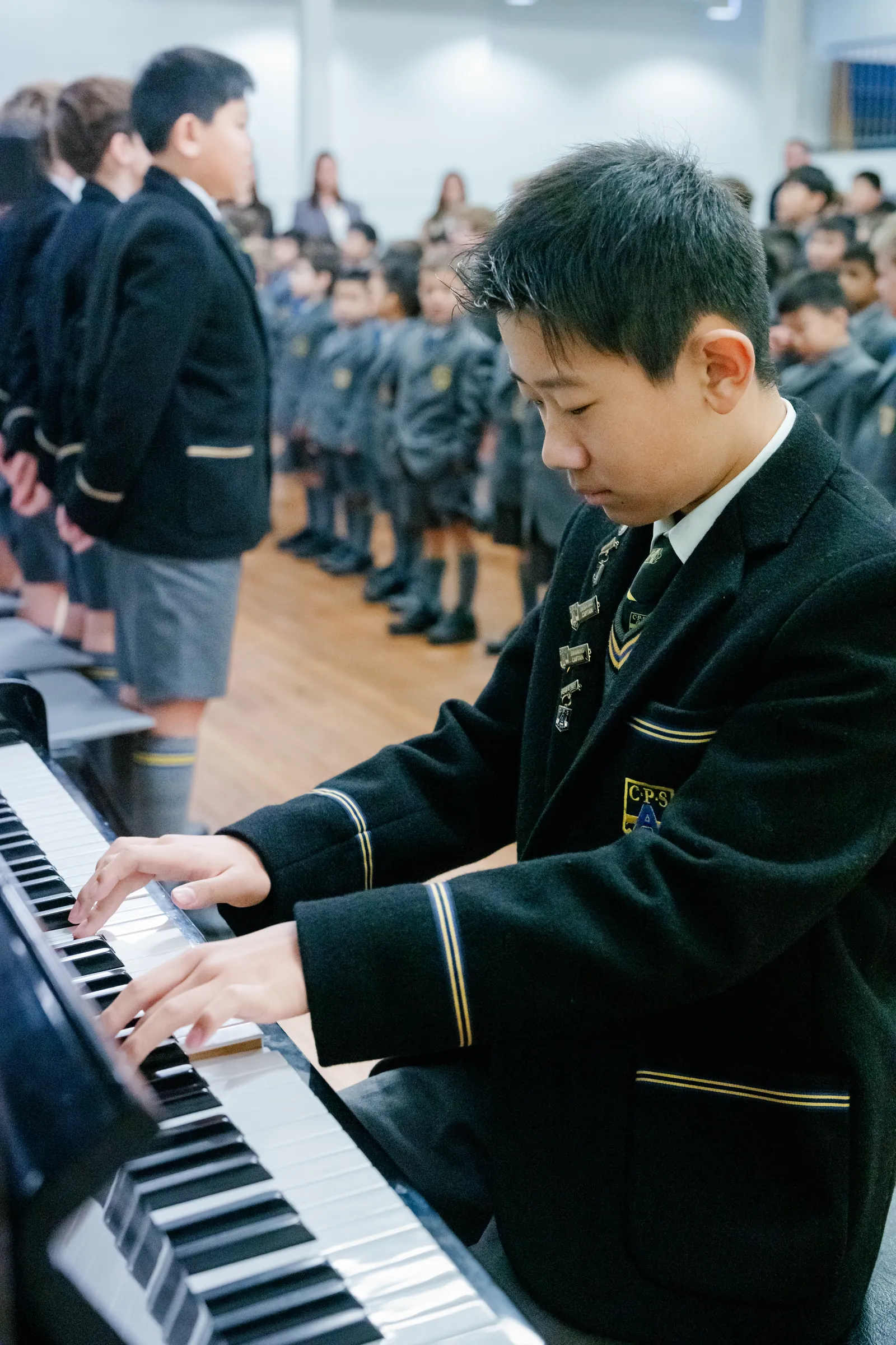 A Coogee Prep boy playing the piano in front of the school