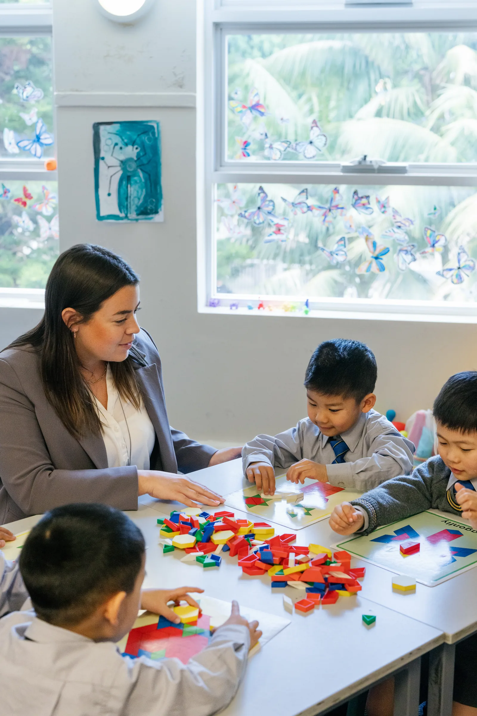 A Coogee Prep teacher guiding boys through a pattern-block activity