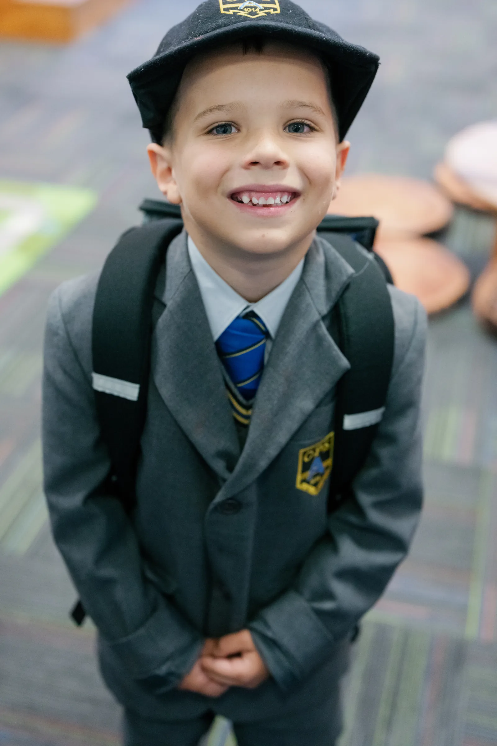 A smiling young Coogee Prep boy in his school cap and blazer